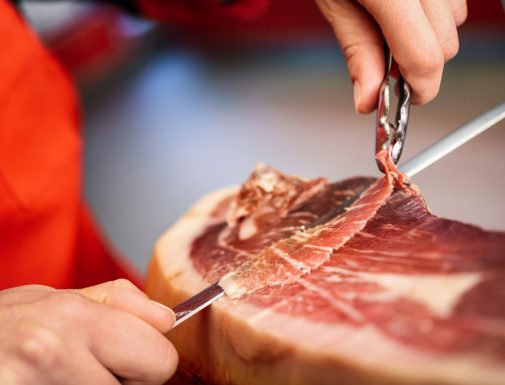 cortador de jamon cortando una loncha de jamón con un cuchillo