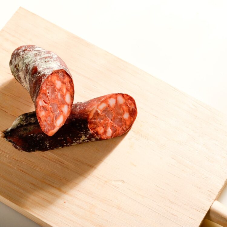 chorizo vela presentado en tabla con lonchas del producto